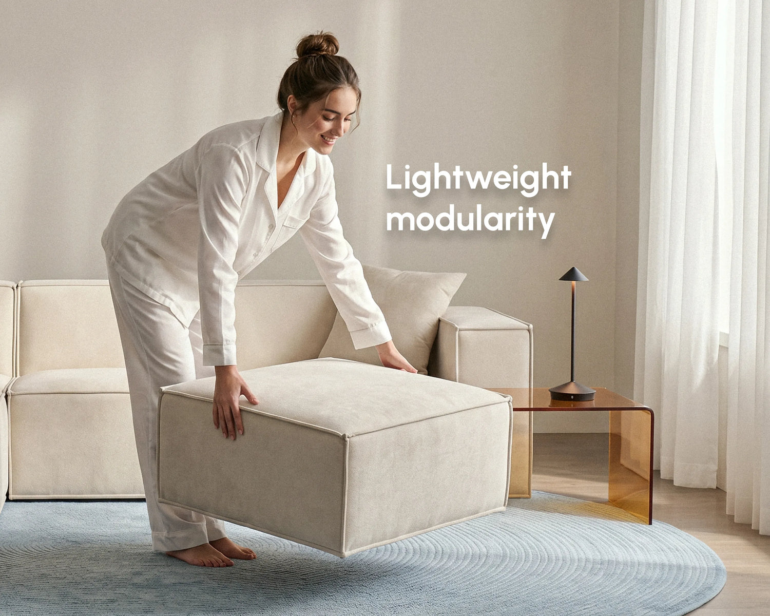 Woman lifting a cream upholstered modular sofa ottoman, showcasing lightweight modularity and flexible living room seating.