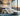 #O2 Bed Helium Cloud in a modern bedroom with a city view, featuring purple and teal throw pillows and a chunky knit blanket