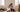 A newlywed couple sitting on the floor of their empty, sunlit flat surrounded by moving boxes